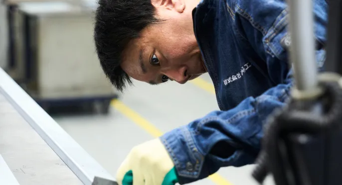 工場で金属加工の作業に集中する社員