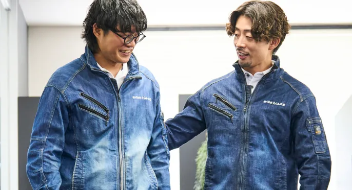 作業場で笑顔で言葉を交わす社員