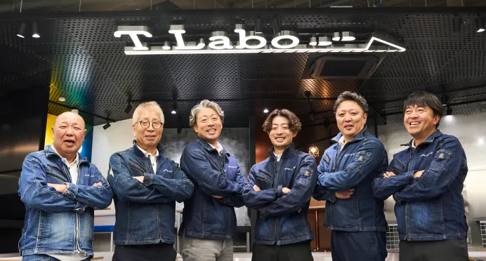 ショールームT.Laboの前で肩を組む社員たち
