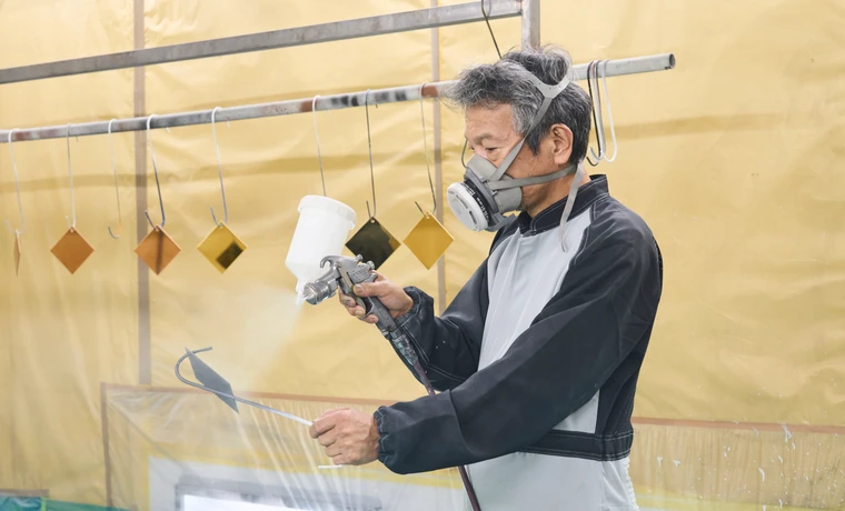 塗装ブースでスプレー塗装をおこなう様子