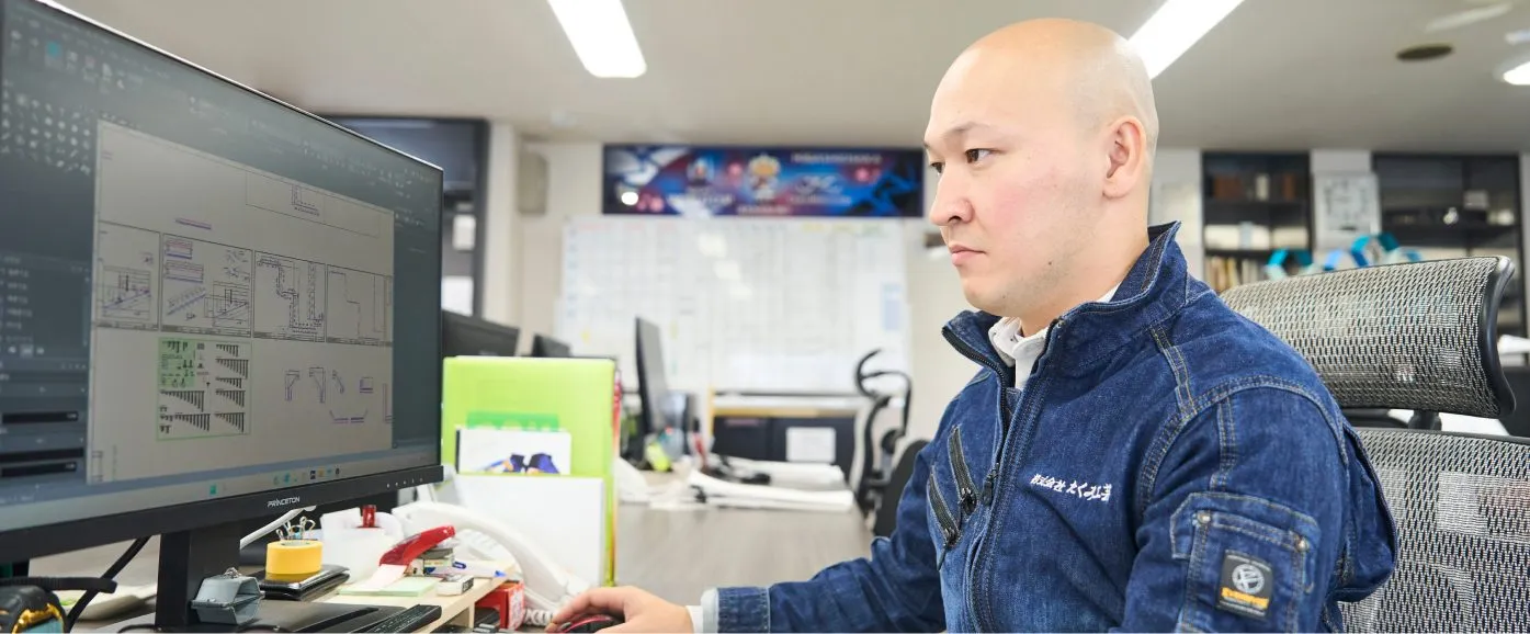 モニターで図面を確認する設計部の仕事風景