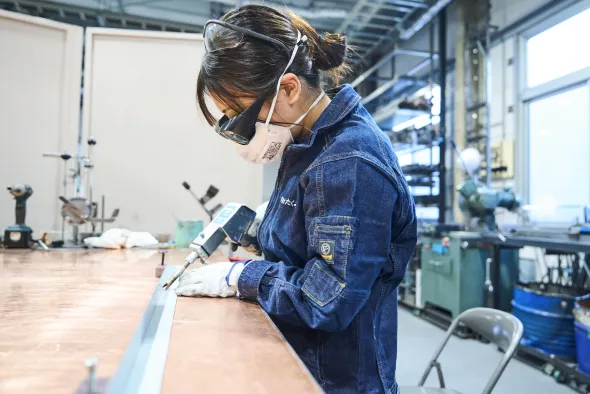 工場で金属を加工する職人